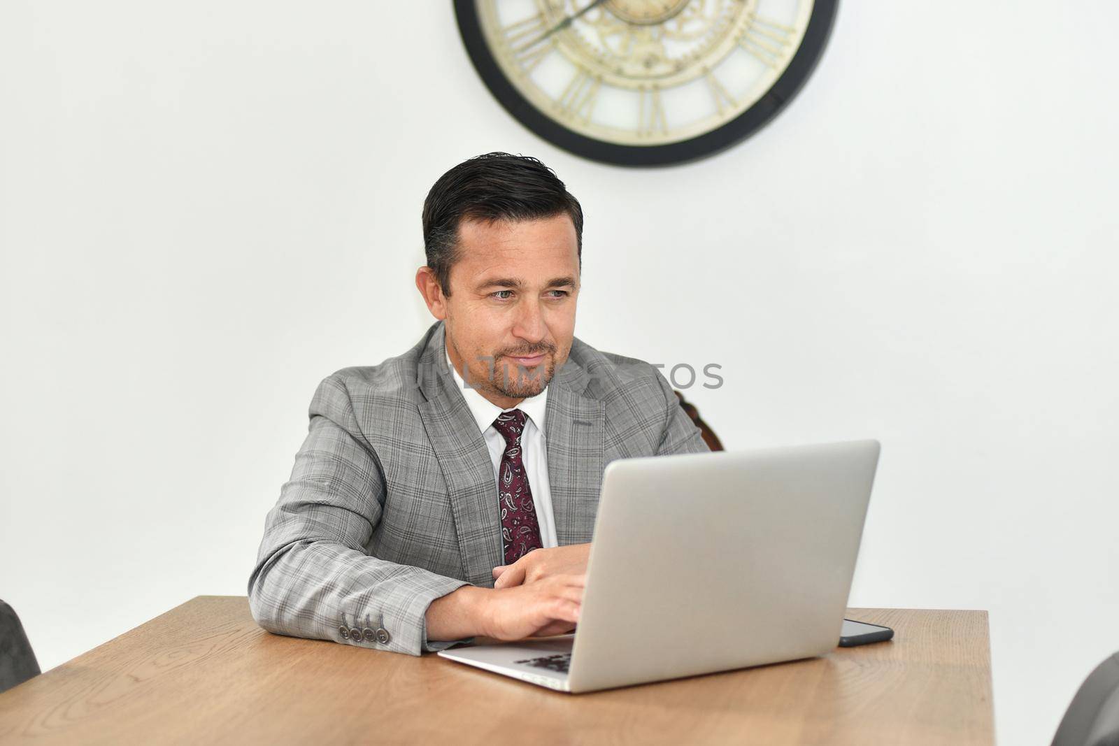 A mature man works at the computer by Godi