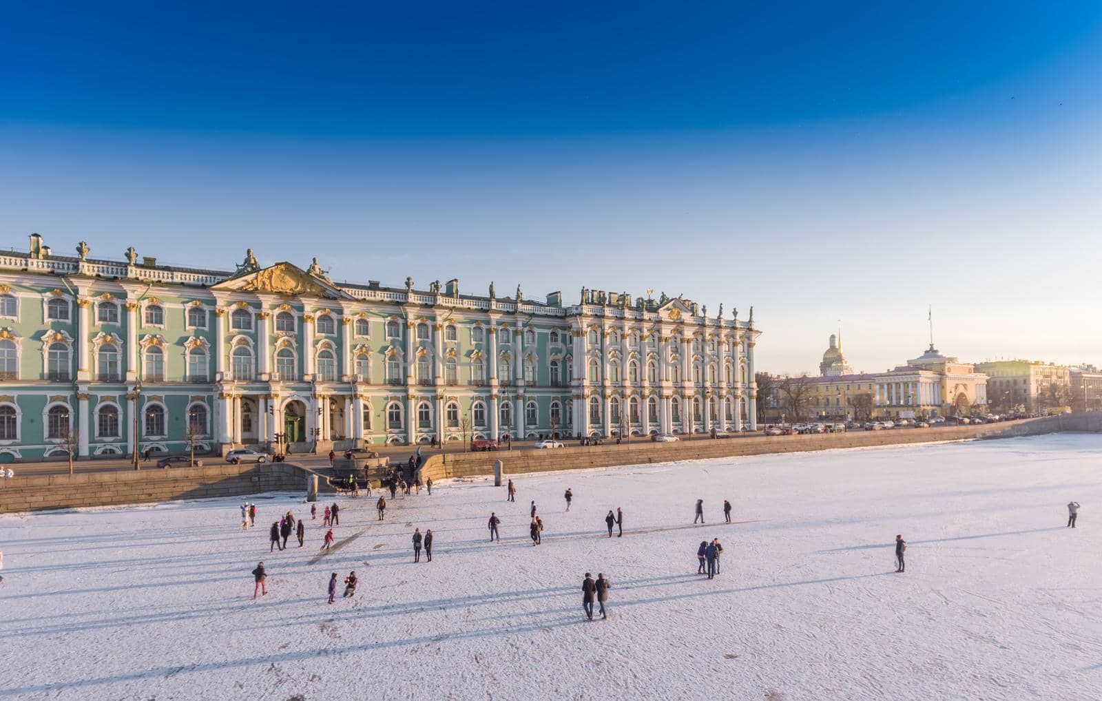 Aerial view of walking people on frozen the Neva River in Saint Petersburg at sunny frosty day, Peter and Paul Fortress, Winter Palace, Admiralty, Palace Bridge, Rostral columns. High quality photo