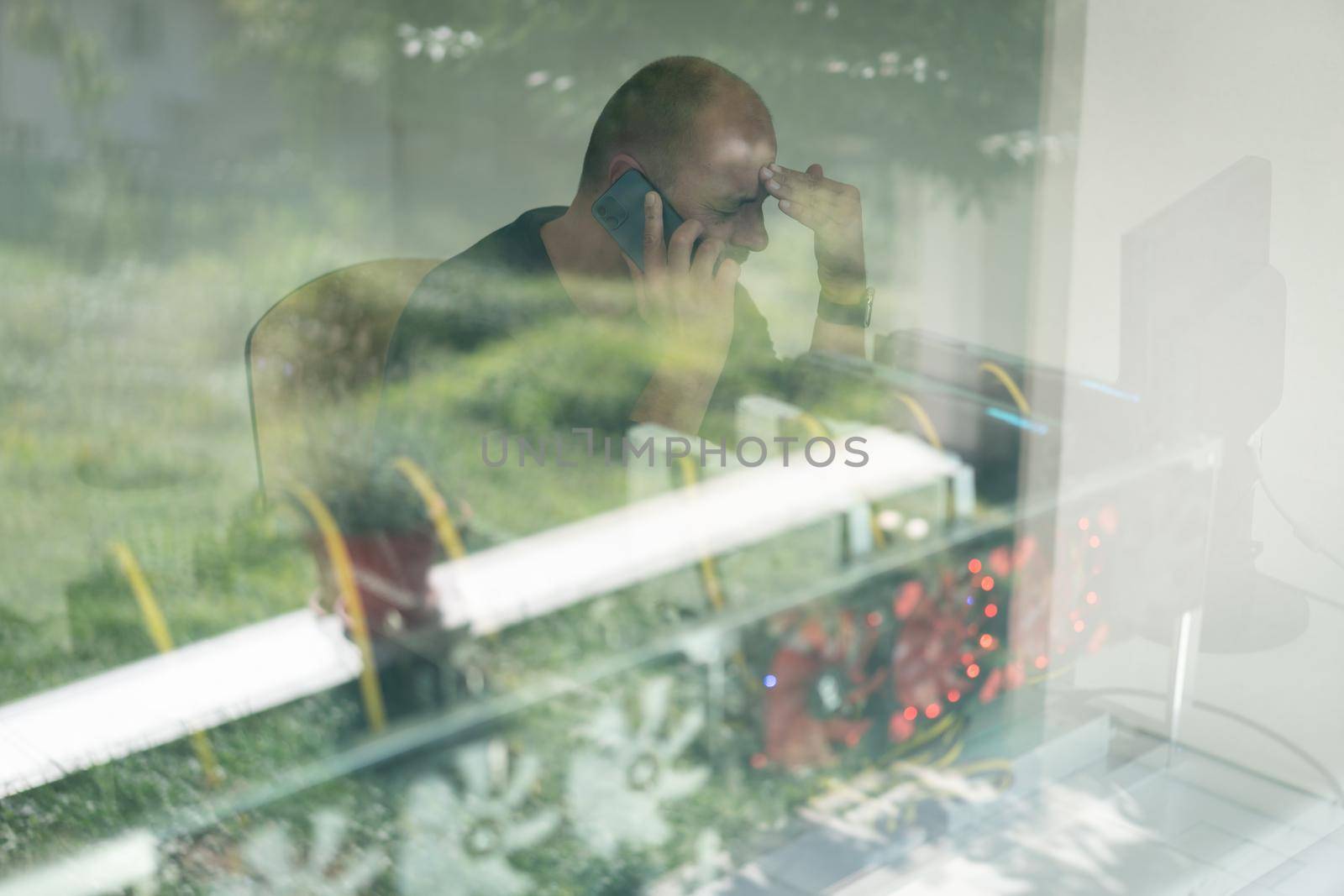 Young programmer adjusting cryptocurrency mining rig to optimal operational settings. High quality photo