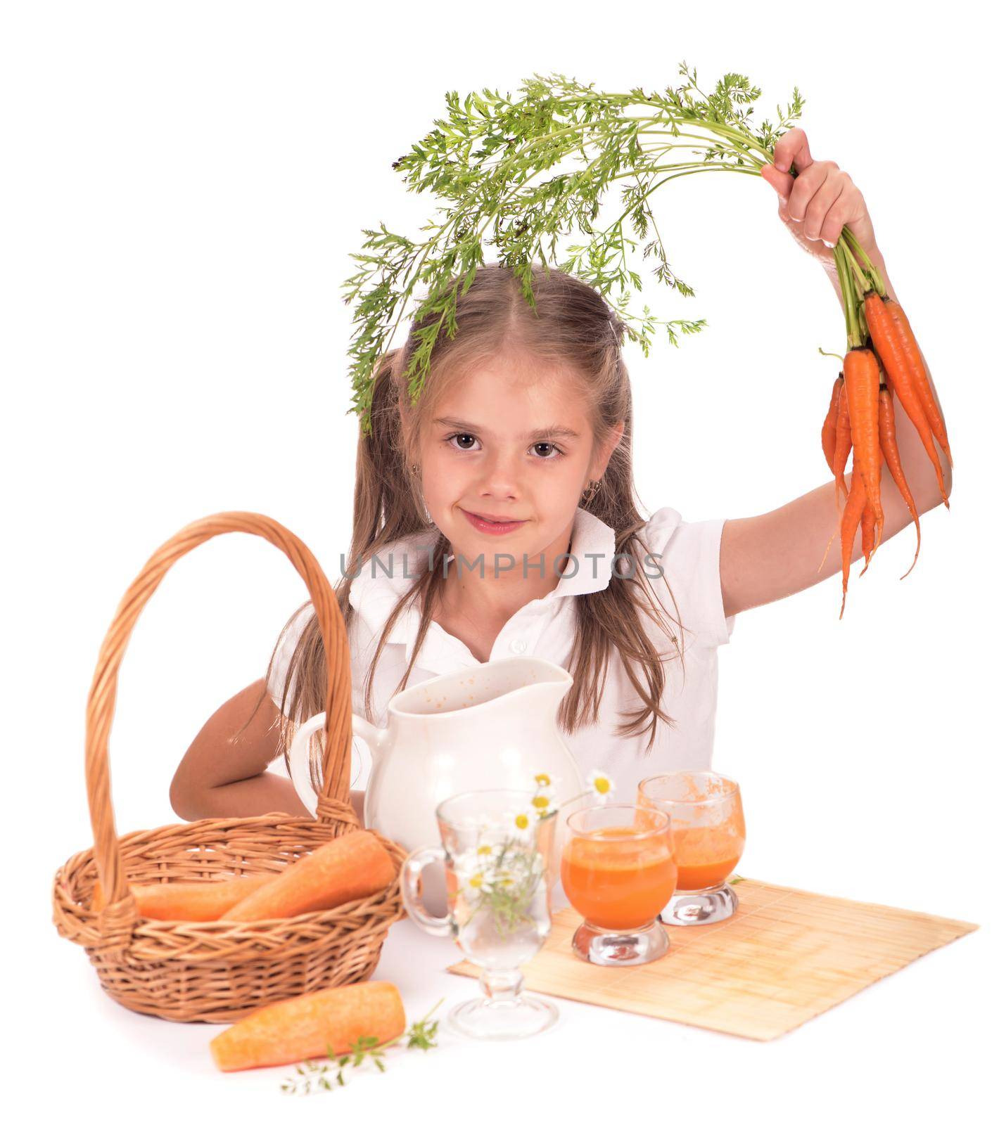 Nice blond baby girl with glass of carrot juice