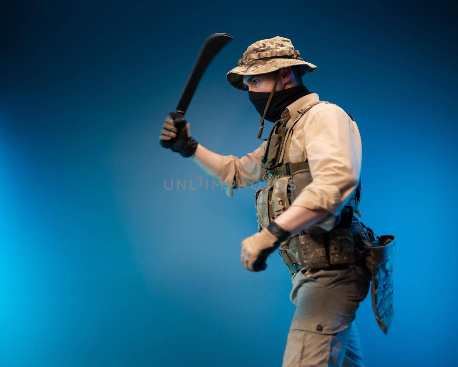 an army soldier in military clothes with a machete in his hand