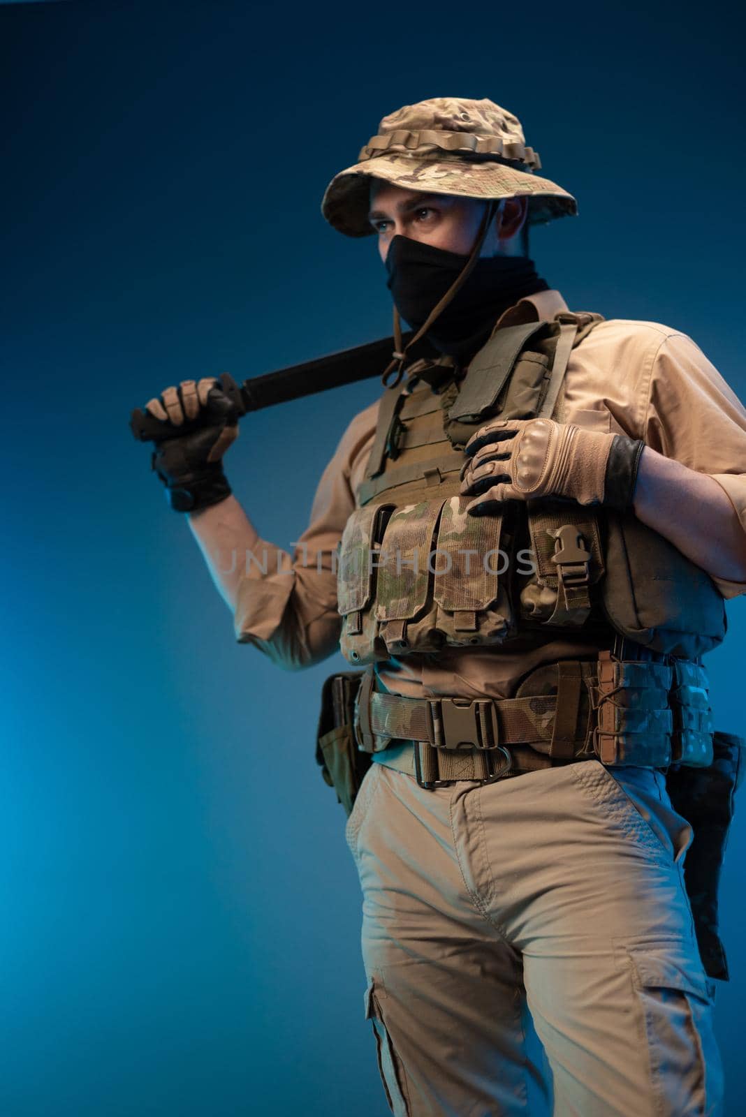 an army soldier in military clothes with a machete in his hand