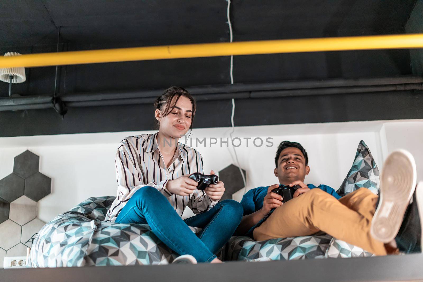 Work hard play hard. Workers Playing computer games man against woman during break in relaxation area at creative startup Office by dotshock