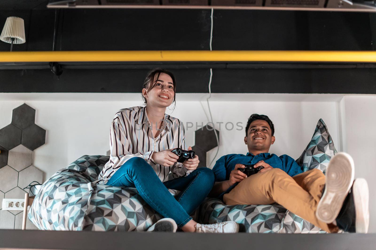 Work hard play hard. Workers Playing computer games man against woman during break in relaxation area at creative startup Office by dotshock