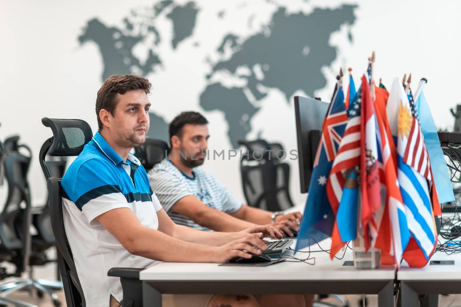 Group of Casual businessmen working on a desktop computer in modern open plan startup office interior. Selective focus. High-quality photo