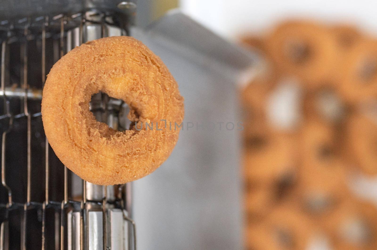 doughnuts or donut on conveyor belt in factory, a type of fried dough confectionery or dessert food. High quality photography.