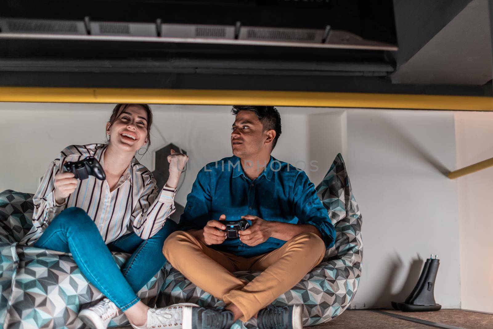 Work hard play hard. Workers Playing computer games man against a woman during break-in relaxation area at creative startup Office. High-quality photo