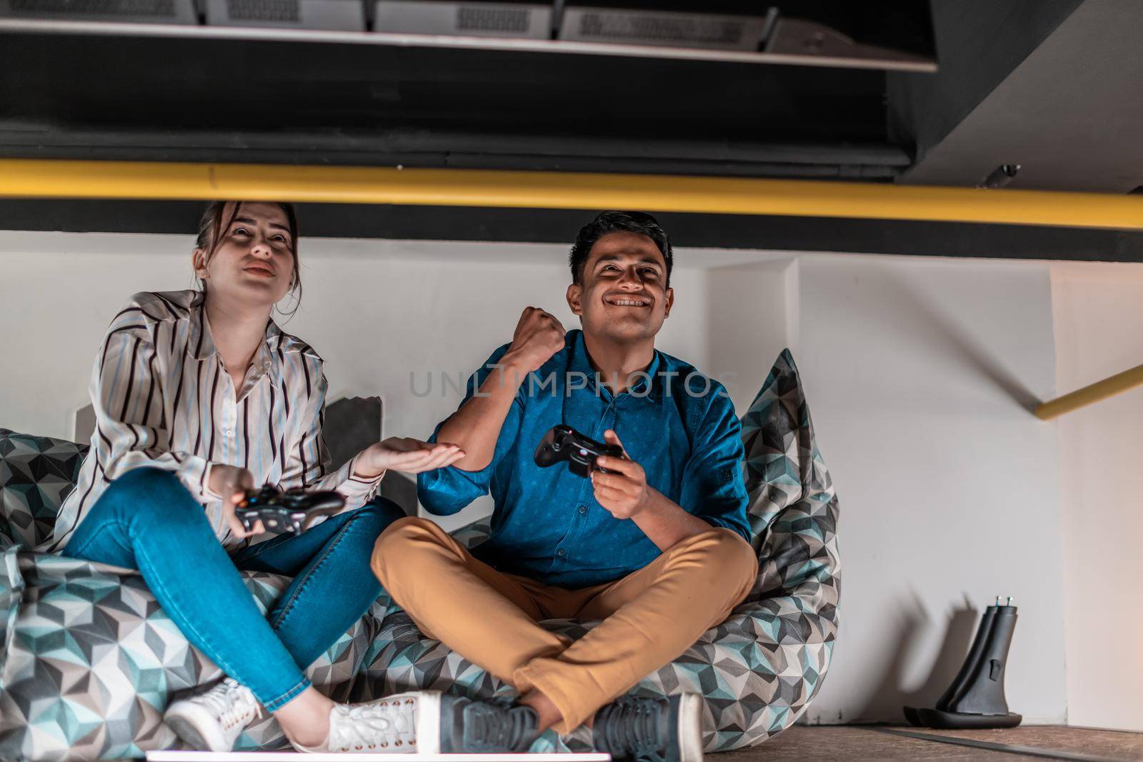 Work hard play hard. Workers Playing computer games man against a woman during break-in relaxation area at creative startup Office. High-quality photo