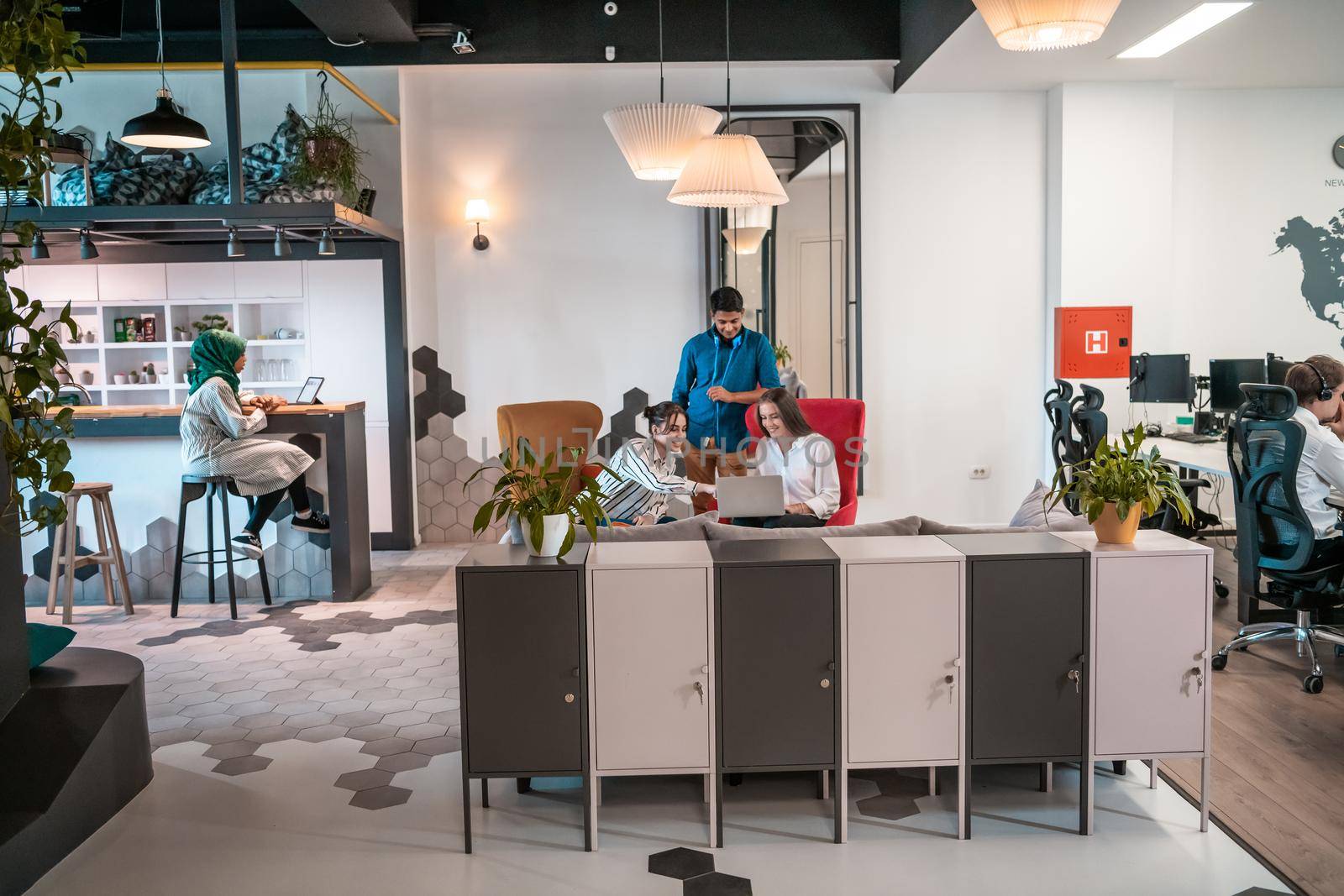 group of casual multiethnic business people taking break from the work doing different things while enjoying free time in relaxation area at modern open plan startup office. High quality photo