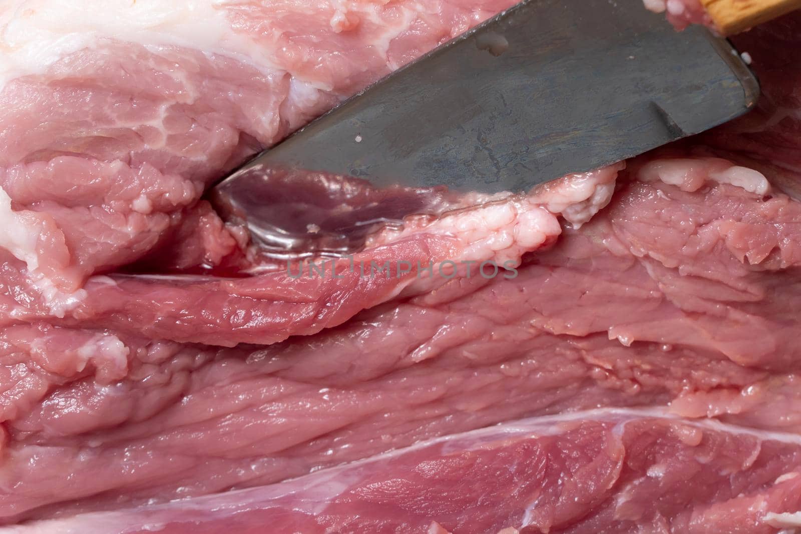 Slice the pork or beef with a knife on the table in close-up.Preparation of meat dishes and food products.Pieces of red meat for shish kebab,barbecue or kebab.Raw fresh meat is cut with a knife.recipe