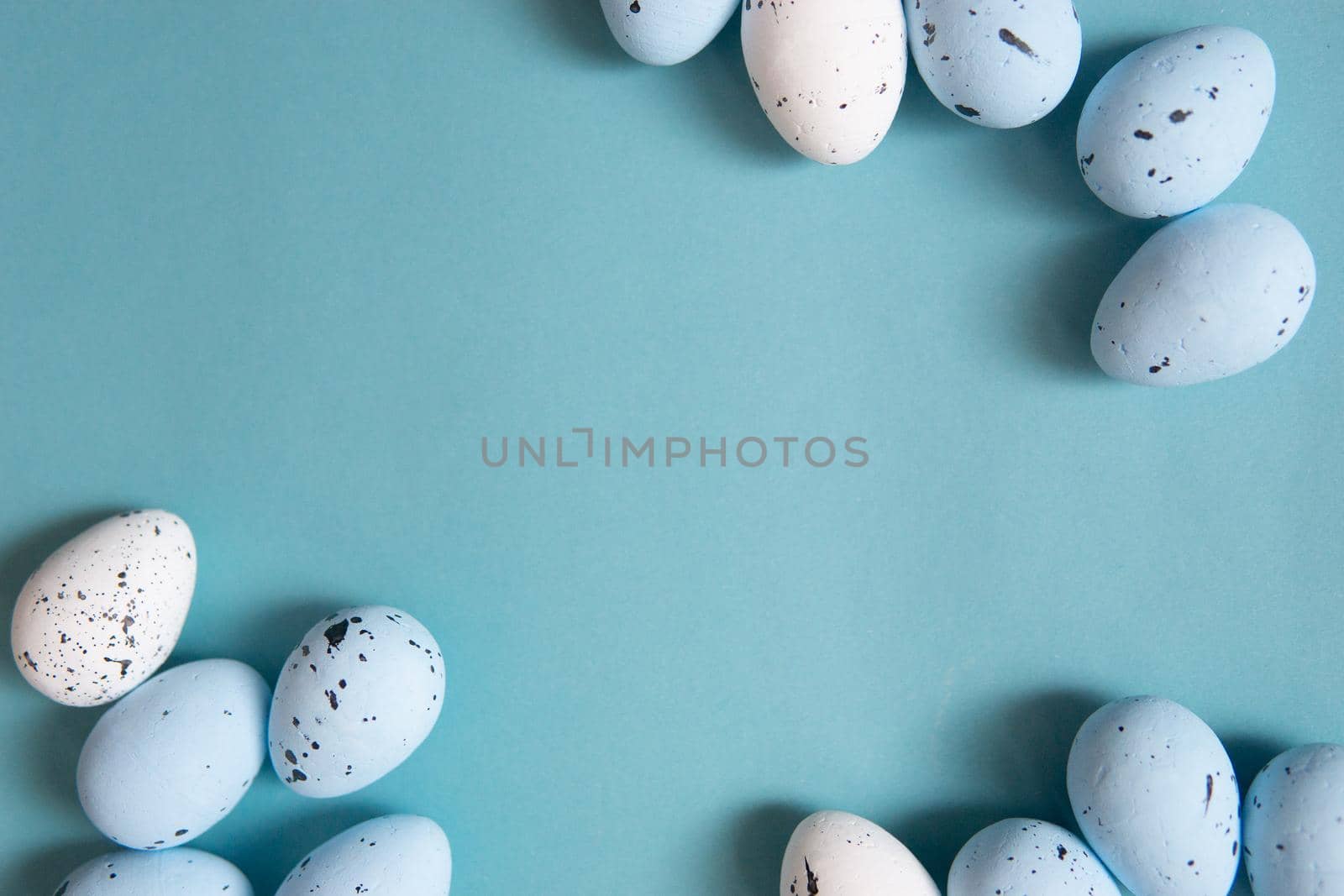 Easter background. Blue and white painted quail eggs on a blue background. Happy Easter holiday.