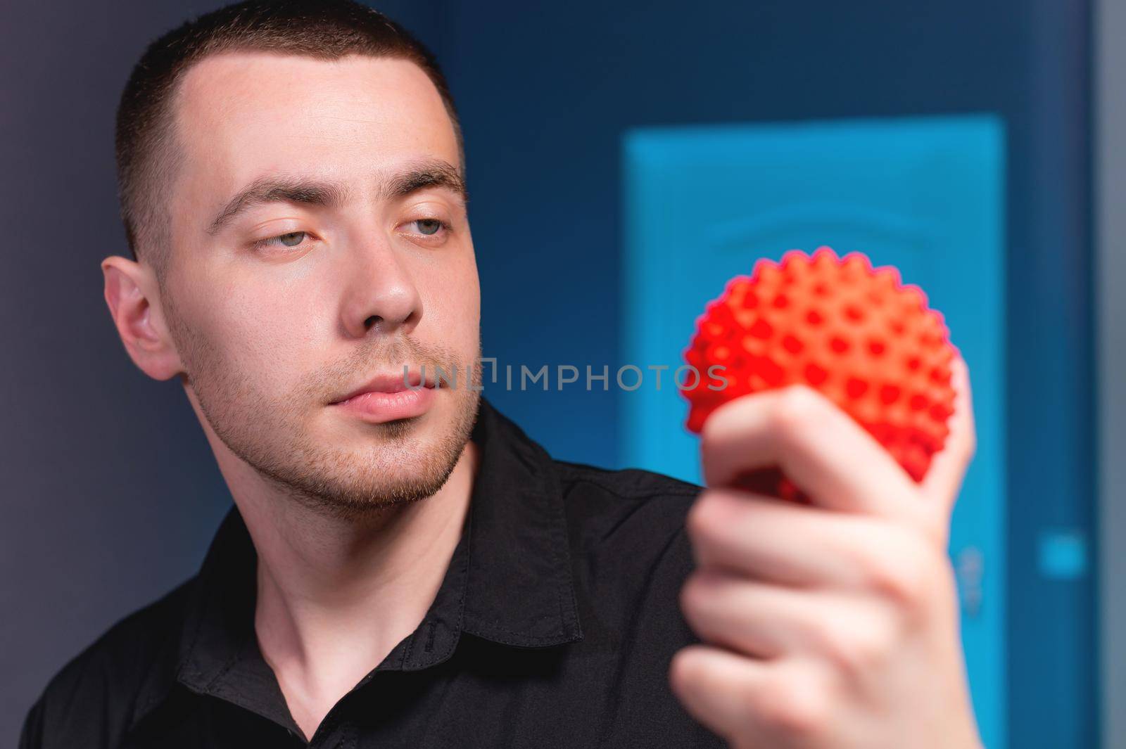 Portrait of a young caucasian doctor physiotherapist massage therapist with a massage ball in his hand. Myofascial release and massage ball copy space.