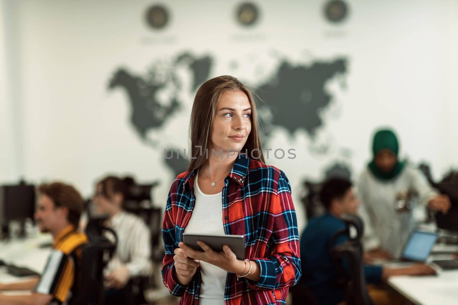 Portrait of businesswoman in casual clothes holding tablet computer at modern startup open plan office interior. Selective focus. High-quality photo