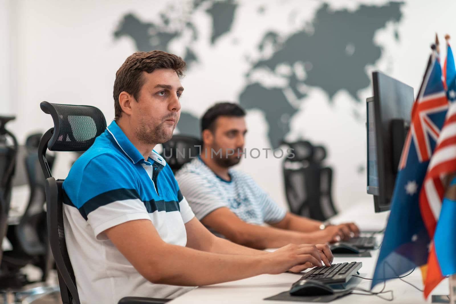 Group of Casual business man working on desktop computer in modern open plan startup office interior. Selective focus by dotshock