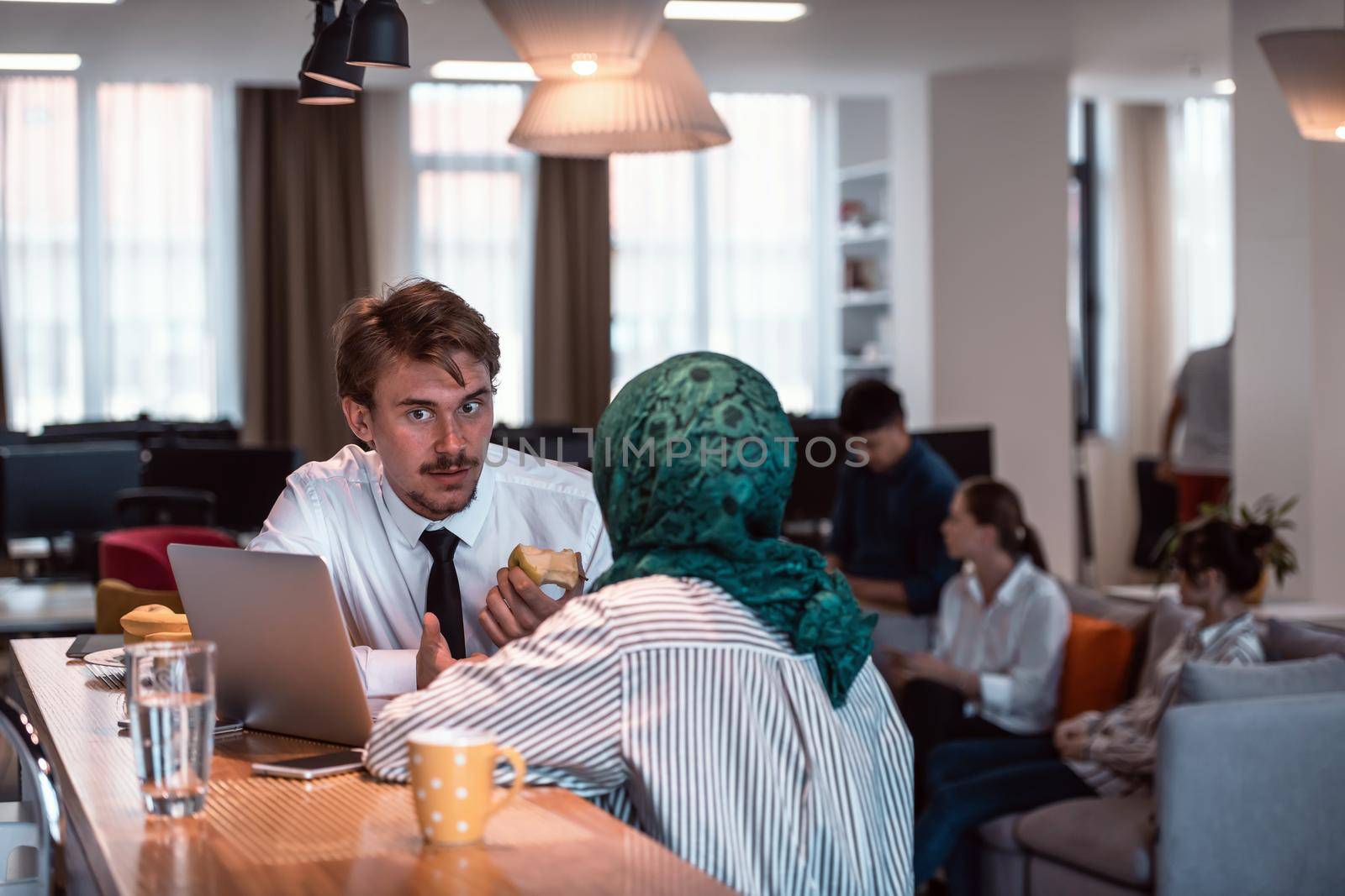 International multicultural business team. A young businessman and businesswoman sit in a modern relaxation space and talk about a new business. High-quality photo