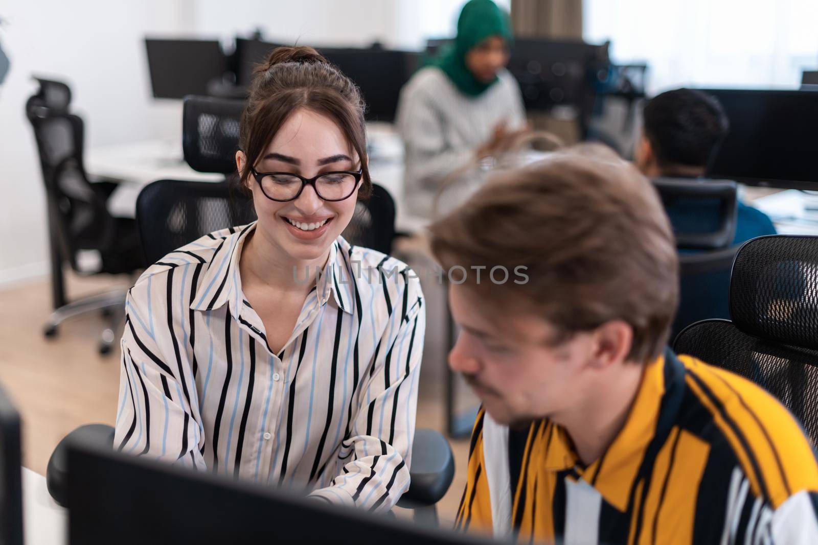 Business couple working together on a project using tablet and desktop computer at modern open plan startup office. Selective focus. High-quality photo