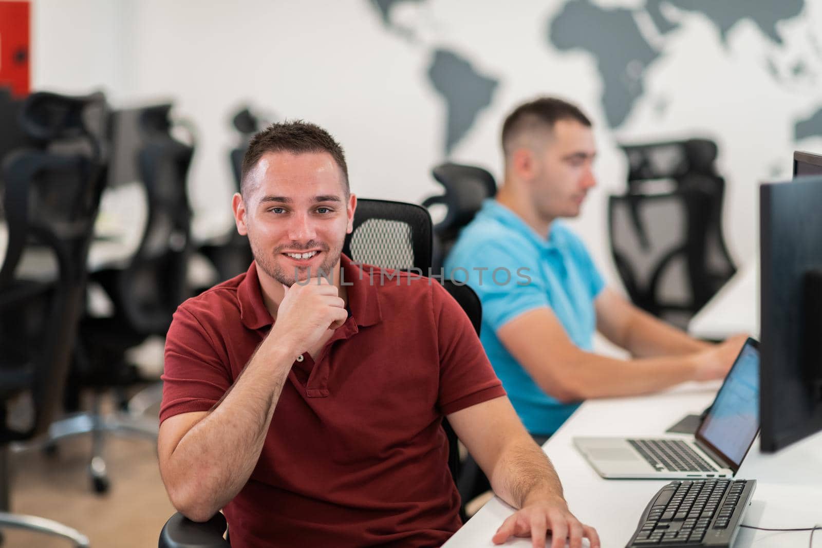 Group of Casual business man working on desktop computer in modern open plan startup office interior. Selective focus by dotshock