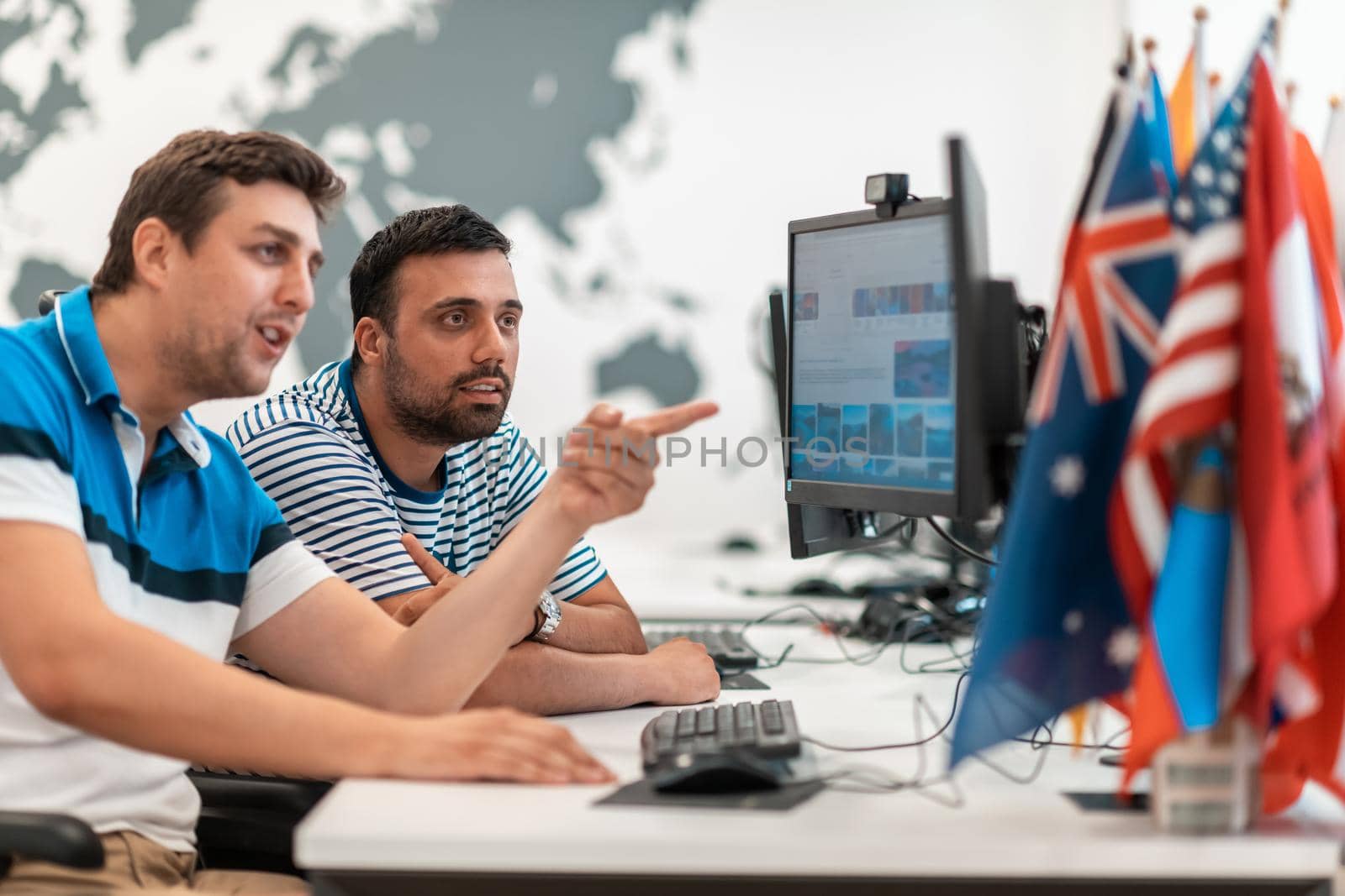 Group of Casual businessmen working on a desktop computer in modern open plan startup office interior. Selective focus. High-quality photo