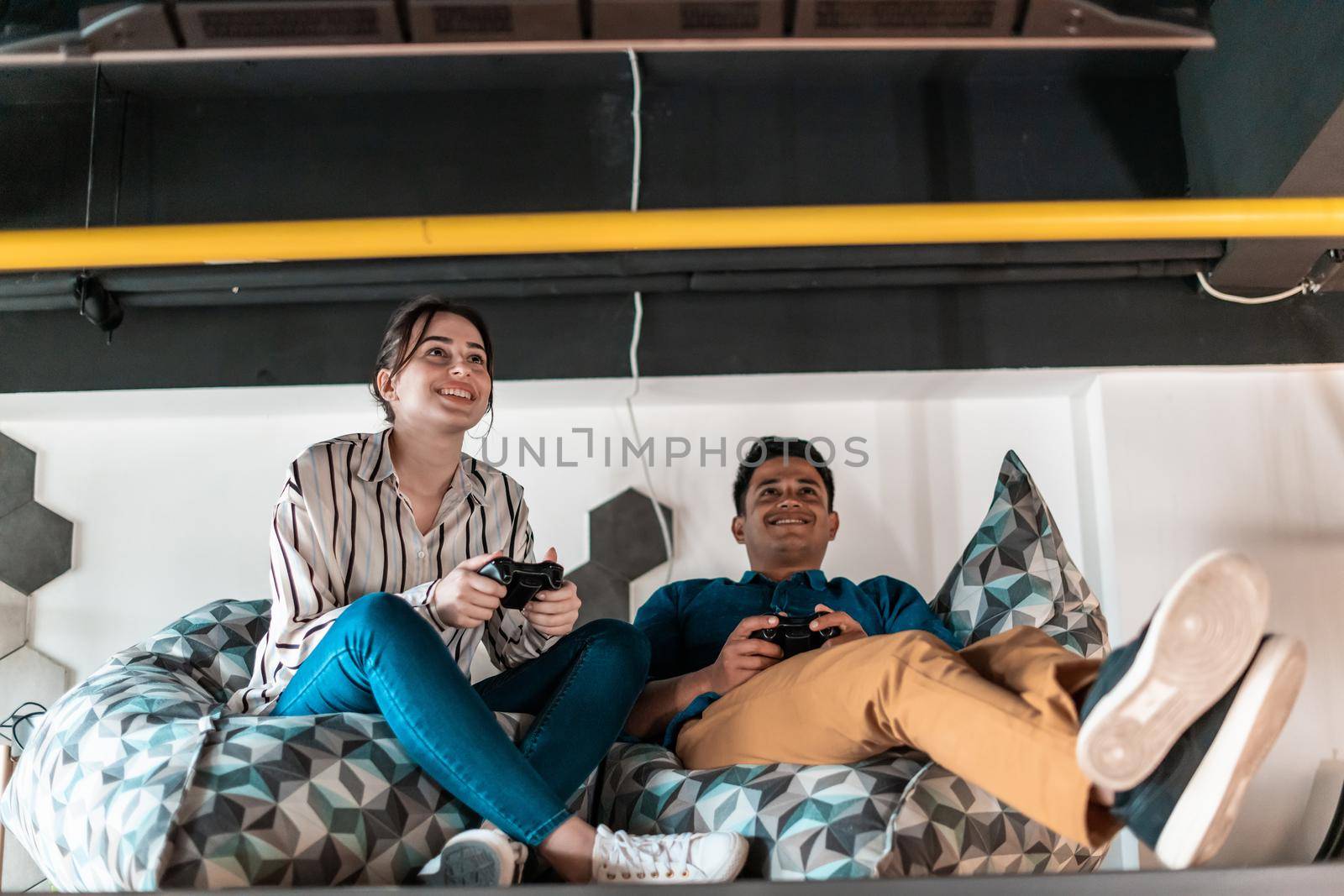 Work hard play hard. Workers Playing computer games man against a woman during break-in relaxation area at creative startup Office. High-quality photo