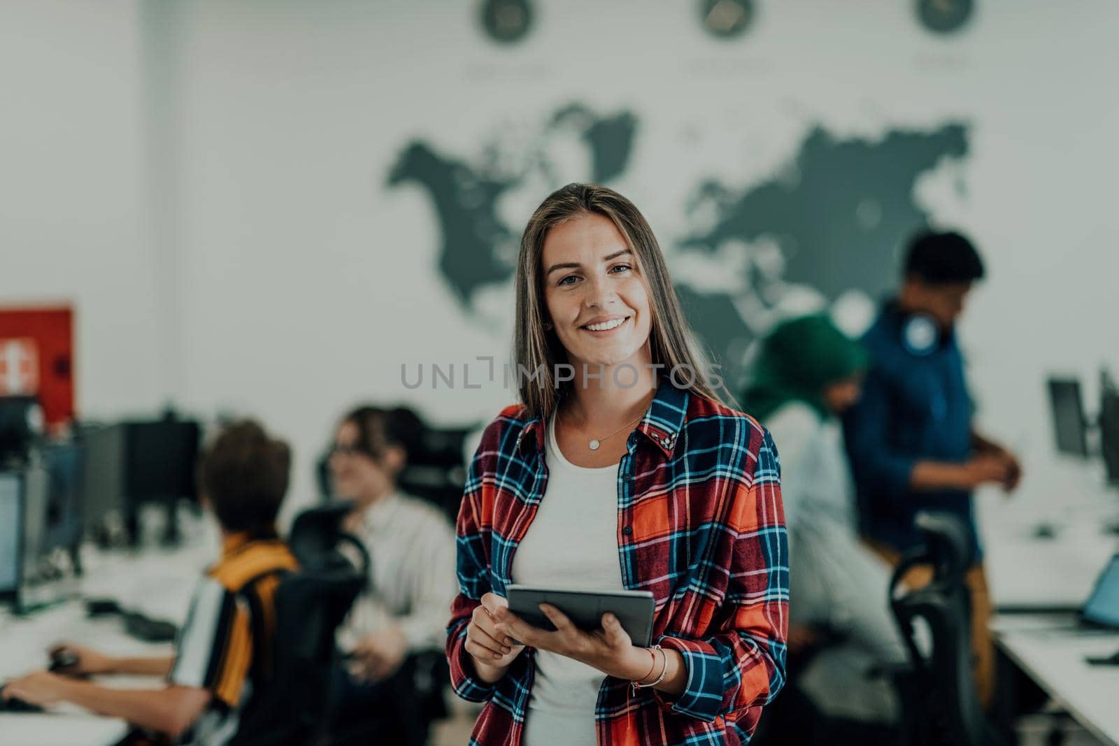 Portrait of businesswoman in casual clothes holding tablet computer at modern startup open plan office interior. Selective focus. High-quality photo