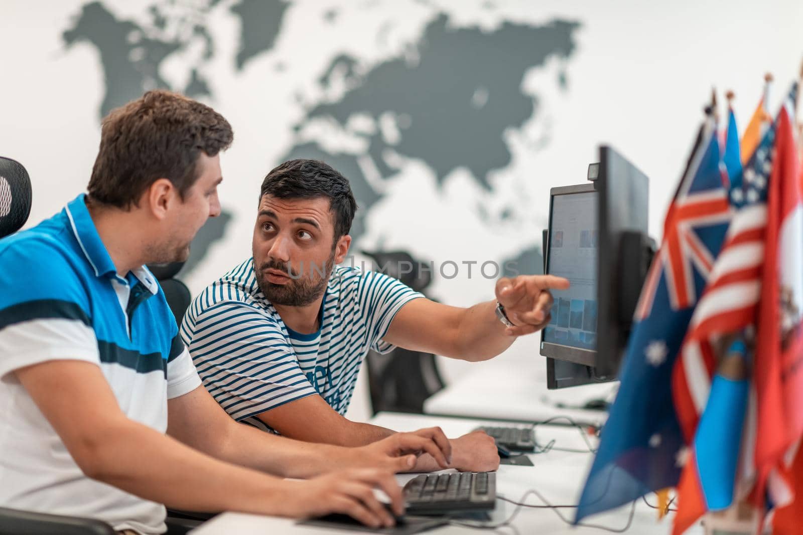 Group of Casual business man working on desktop computer in modern open plan startup office interior. Selective focus by dotshock