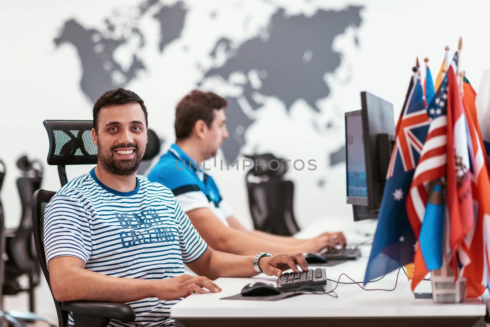 Group of Casual businessmen working on a desktop computer in modern open plan startup office interior. Selective focus. High-quality photo