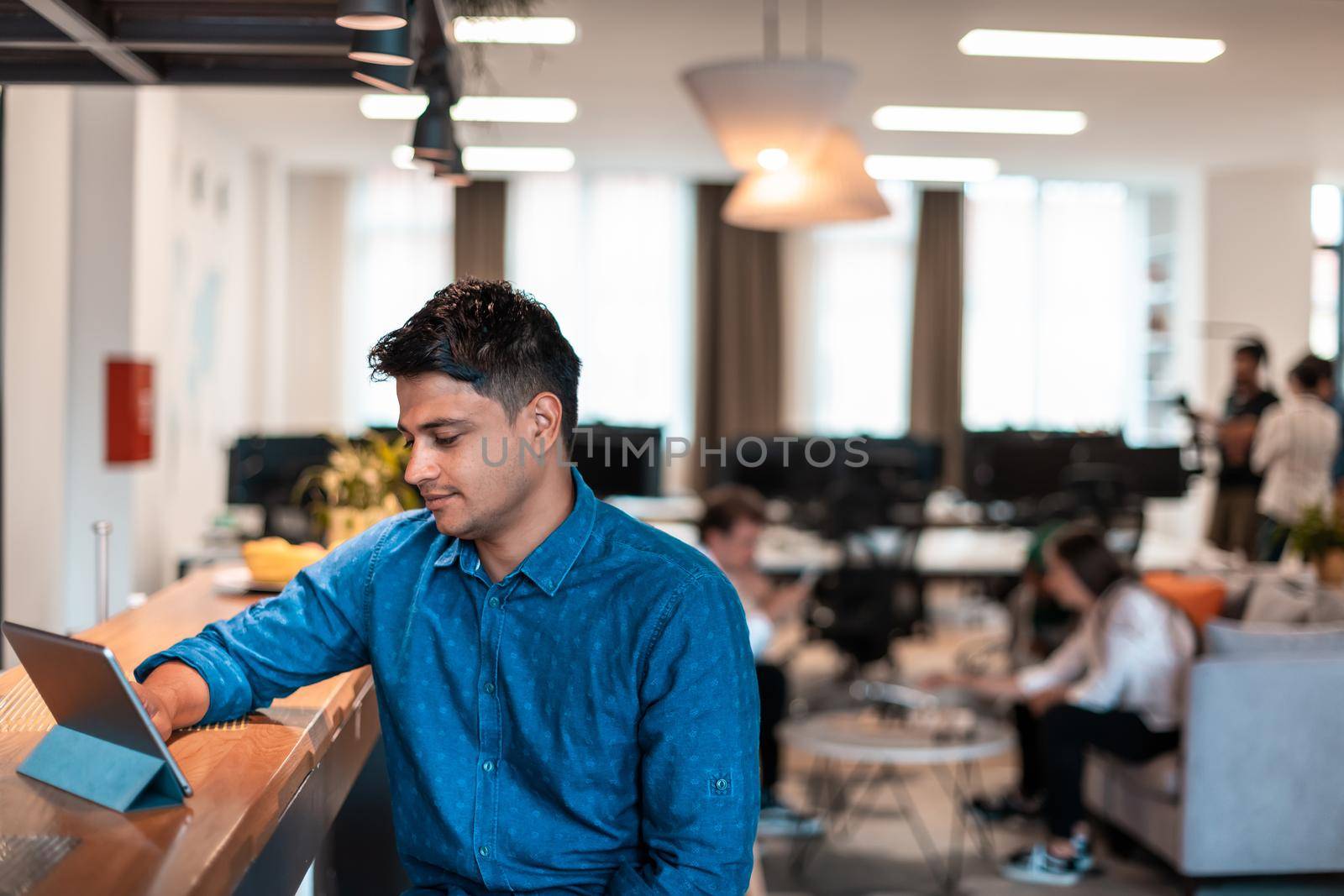 Casual business man with headphones around his using laptop for online meeting. Selective focus by dotshock