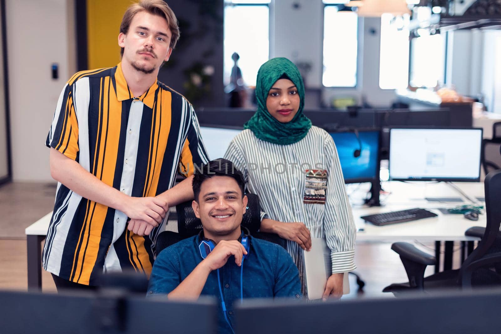 Multiethnic startup business team Arabian woman wearing a hijab on meeting in modern open plan office interior brainstorming, working on laptop and desktop computer. Selective focus. High-quality photo