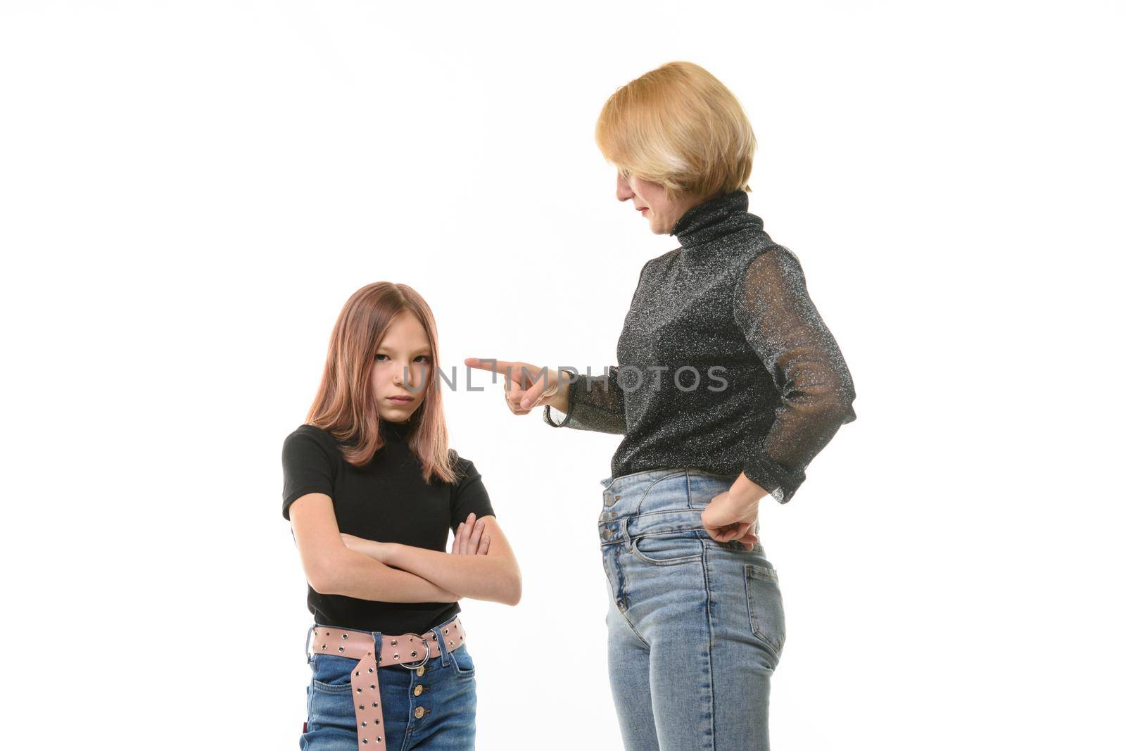 Woman scolding her daughter, upset daughter looks into the frame, close-up portrait a