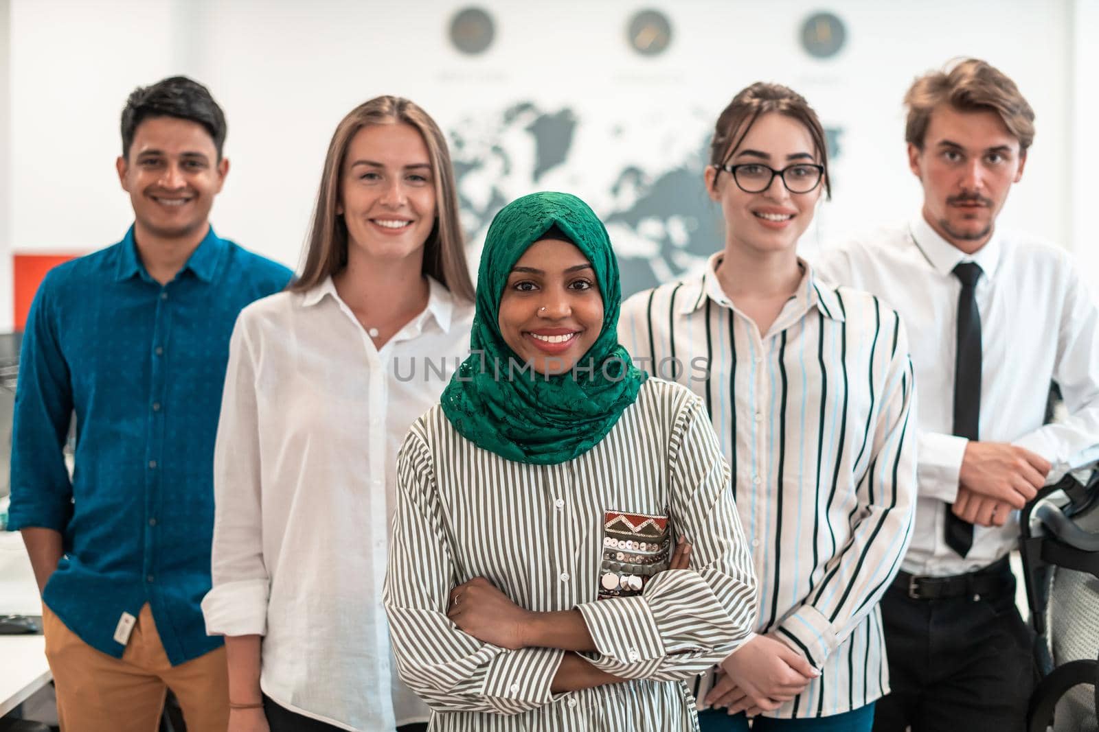 Portrait of young excited multiethnics business team of software developers standing and looking at camera at modern startup office by dotshock