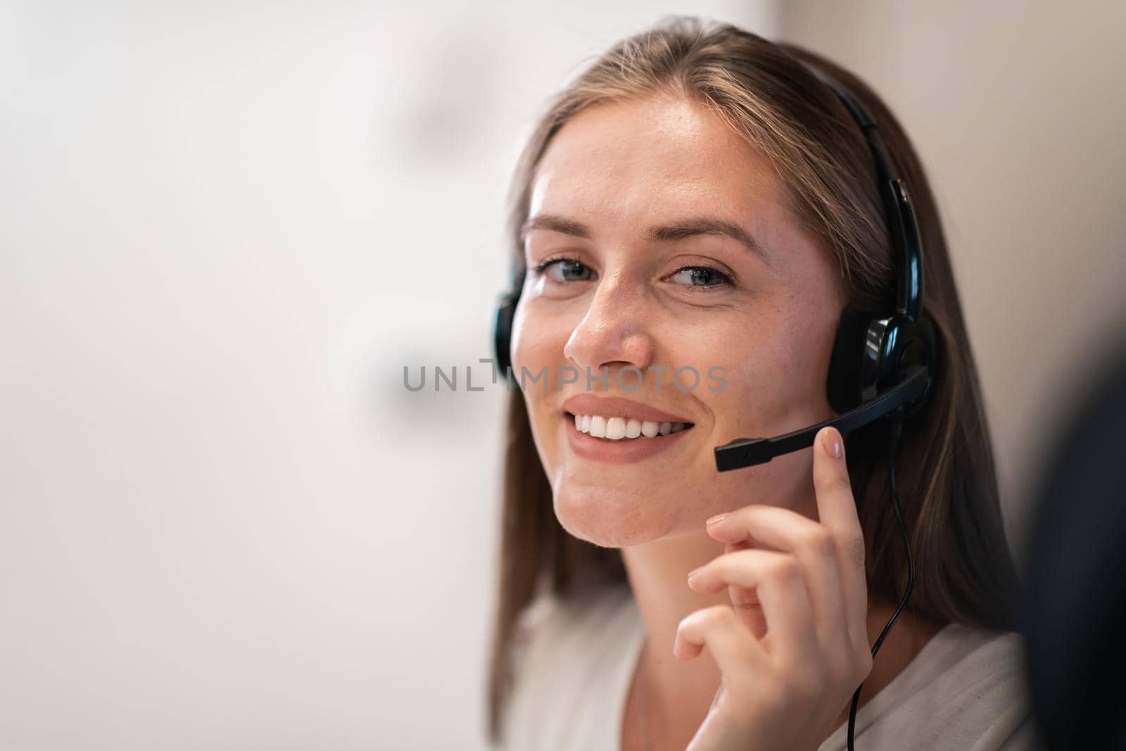 Helpline female operator with headphones in a call center.Business woman with headsets working in a call center. Selective focus. High-quality photo