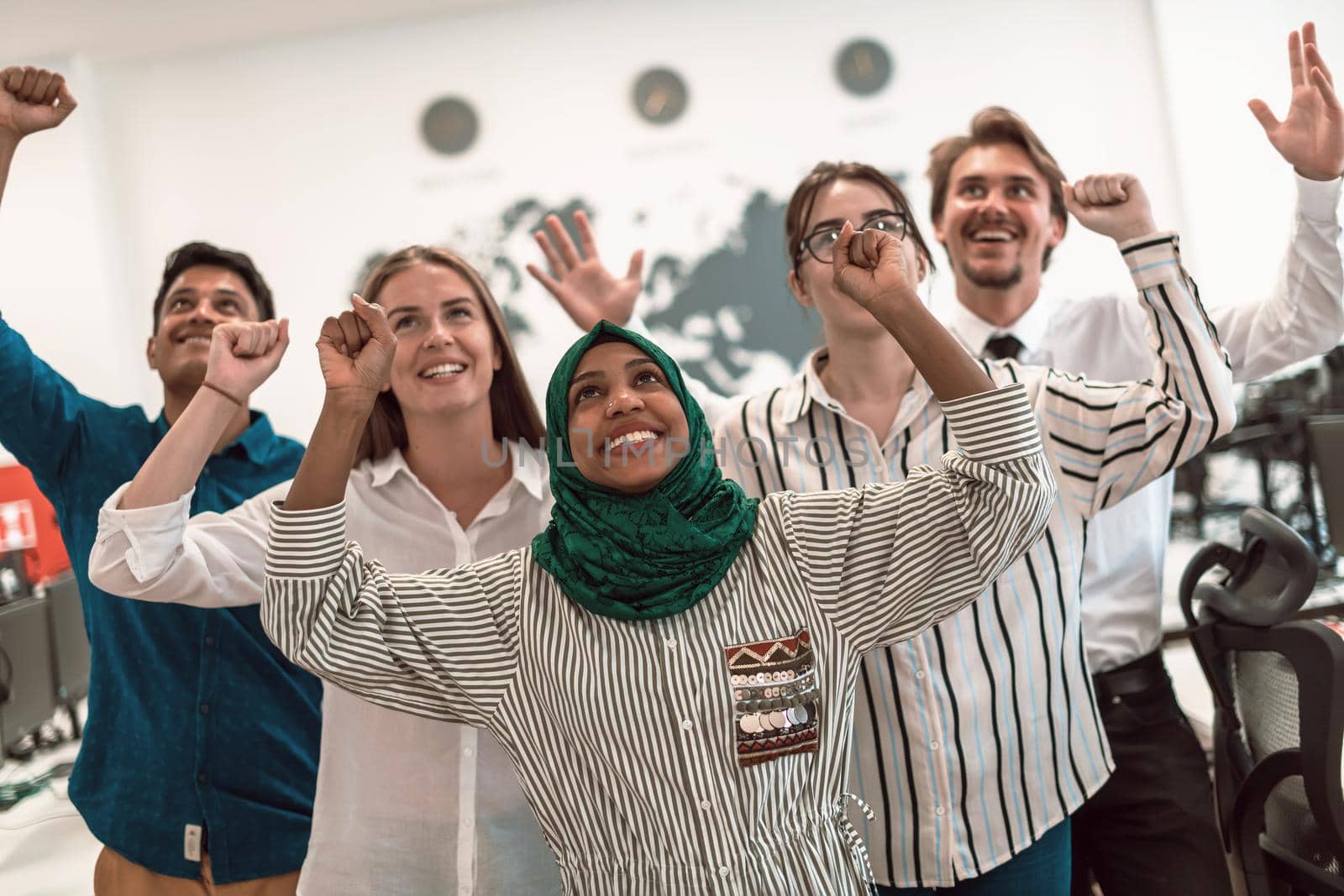 Portrait of young excited multiethnics business team of software developers standing and looking at camera at modern startup office by dotshock