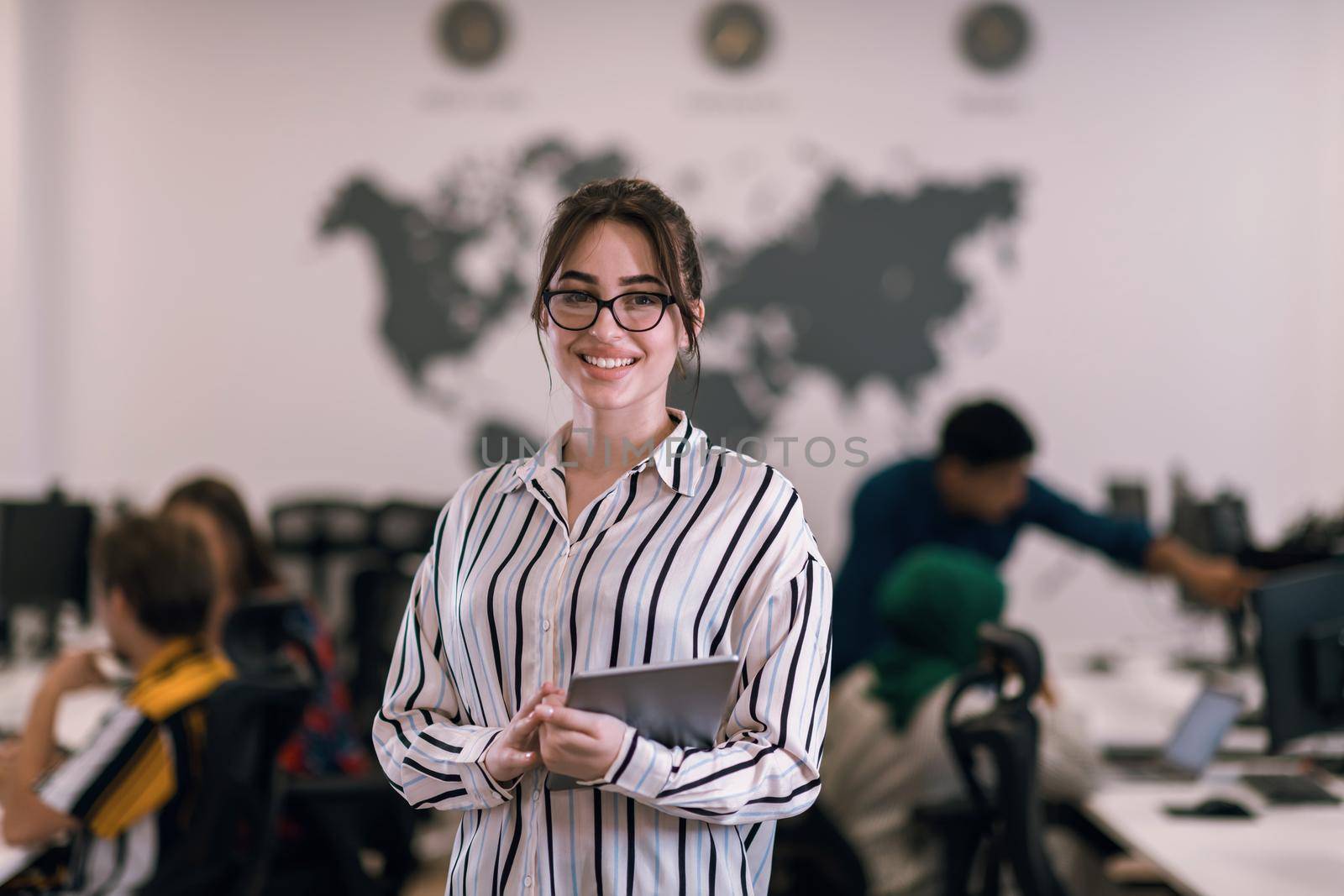 Portrait of businesswoman in casual clothes holding tablet computer at modern startup open plan office interior. Selective focus by dotshock