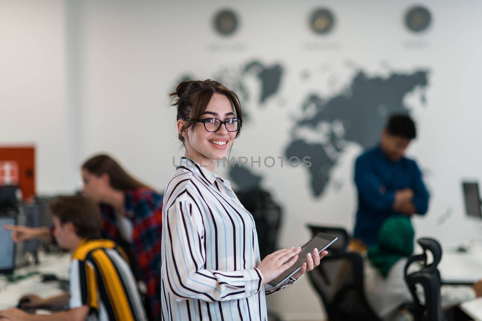 Portrait of businesswoman in casual clothes holding tablet computer at modern startup open plan office interior. Selective focus. High-quality photo