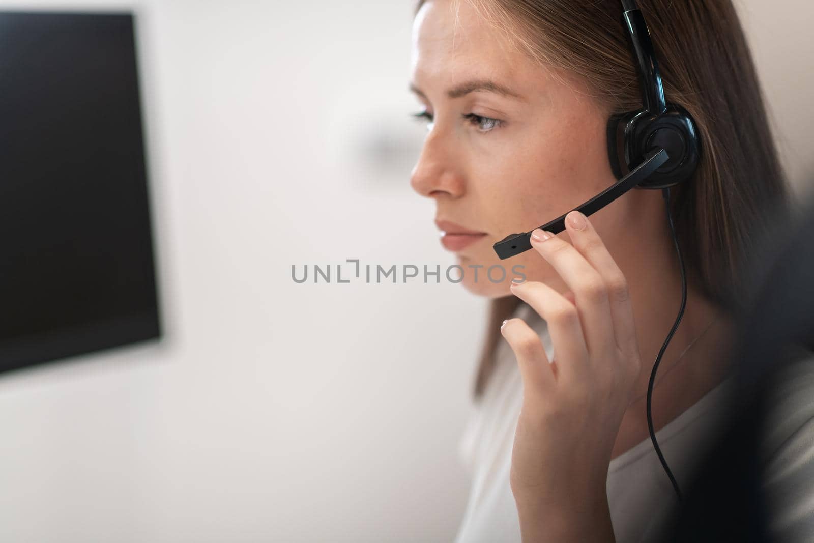 Helpline female operator with headphones in call centre.Business woman with headsets working in a call center. Selective focus by dotshock