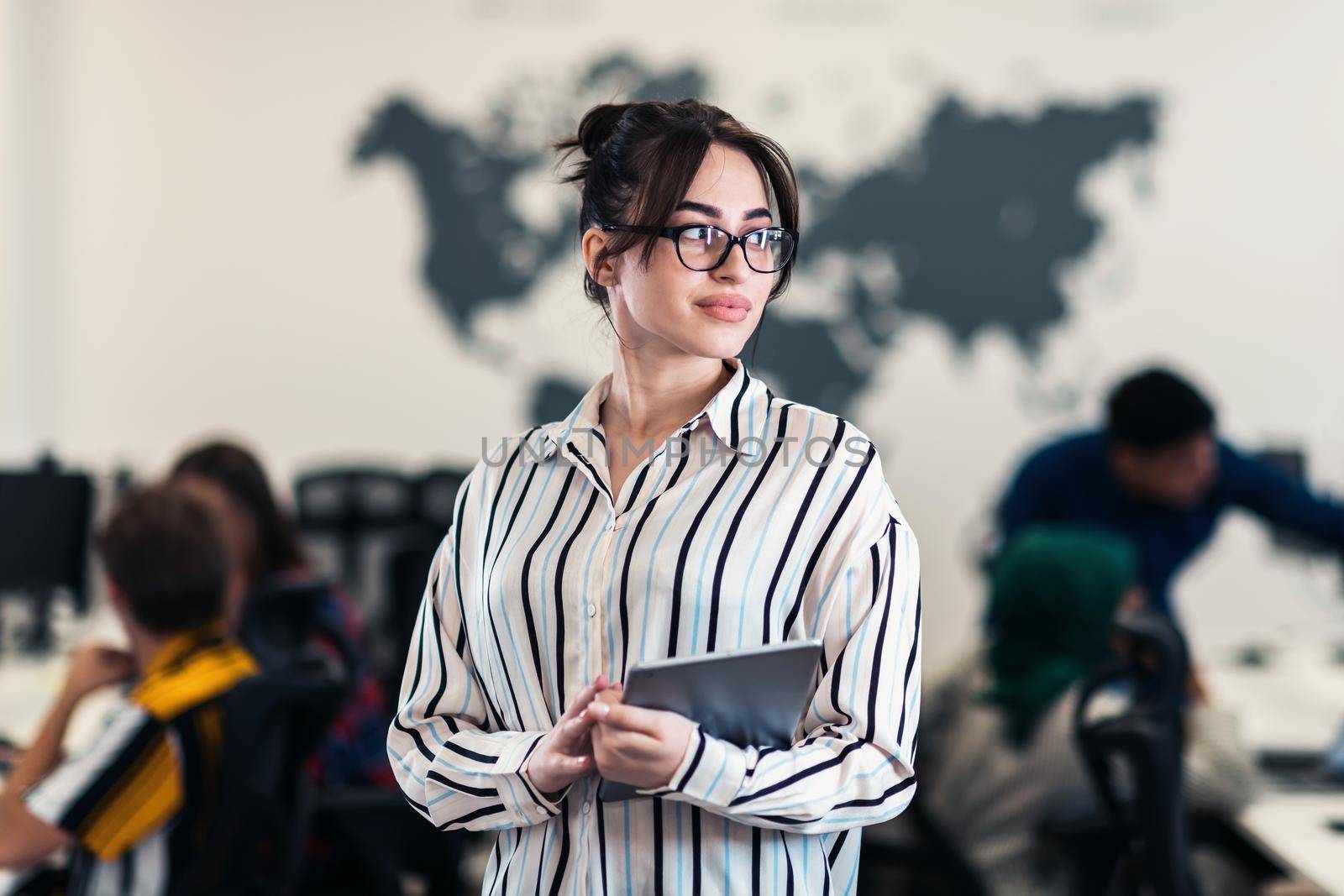 Portrait of businesswoman in casual clothes holding tablet computer at modern startup open plan office interior. Selective focus by dotshock