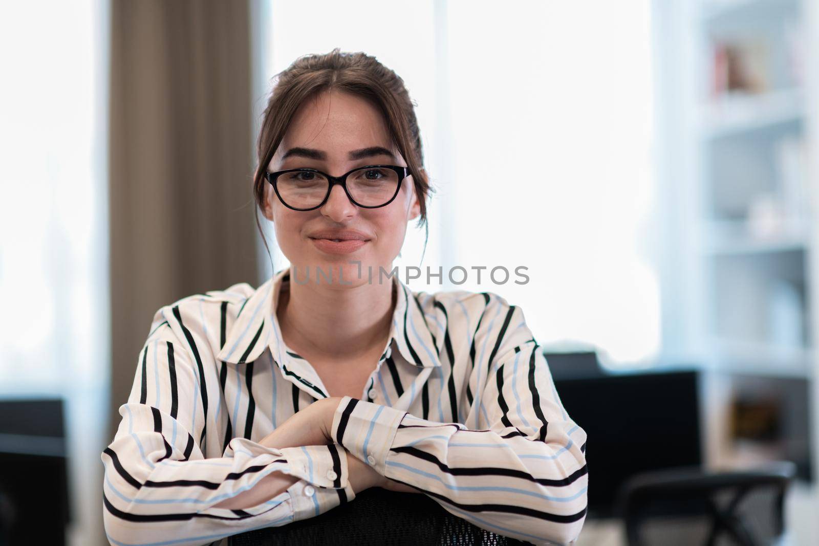 Portrait of businesswoman in casual clothes with glasses at modern startup open plan office interior. Selective focus. High-quality photo