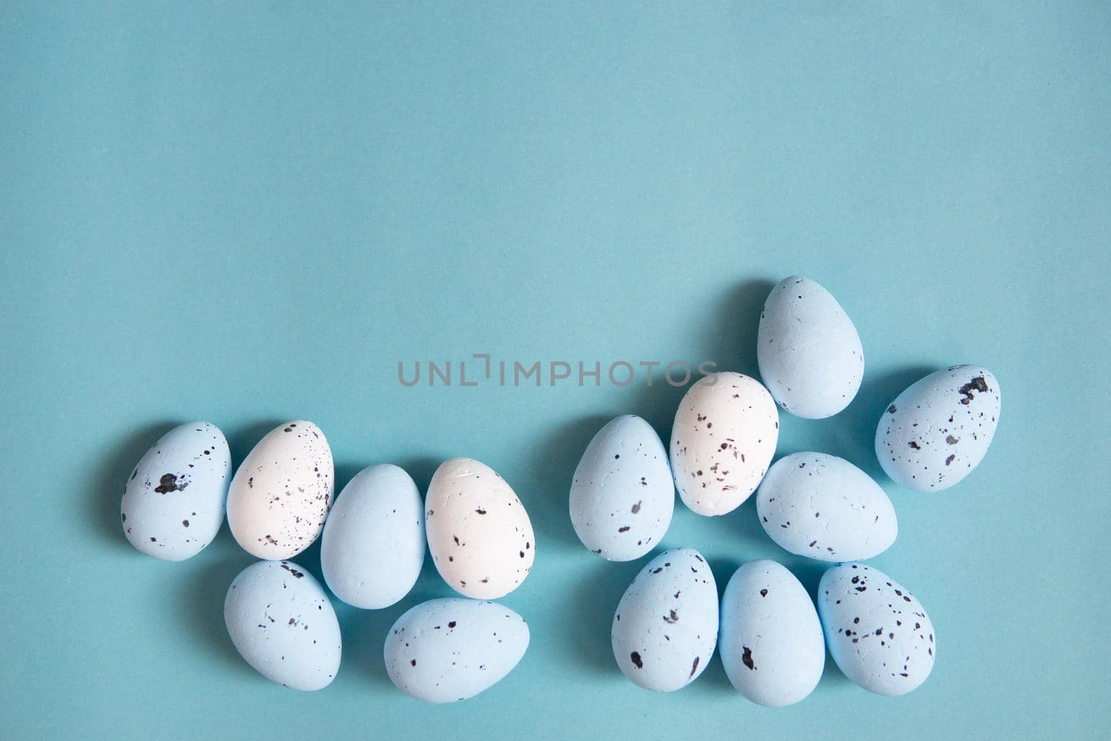 Easter background. Blue and white painted quail eggs on a blue background. Happy Easter holiday.