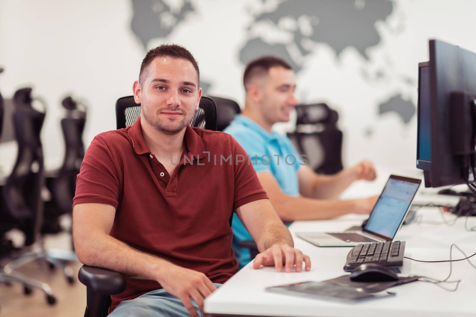 Group of Casual businessmen working on a desktop computer in modern open plan startup office interior. Selective focus. High-quality photo