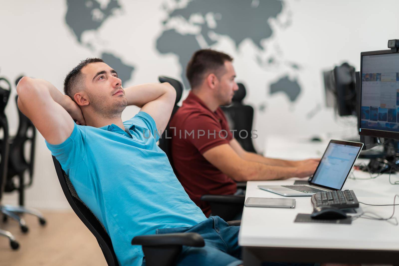 A time to relax. Young tired casual businessman relaxing at the desk in his office. Selective photo. High-quality photo