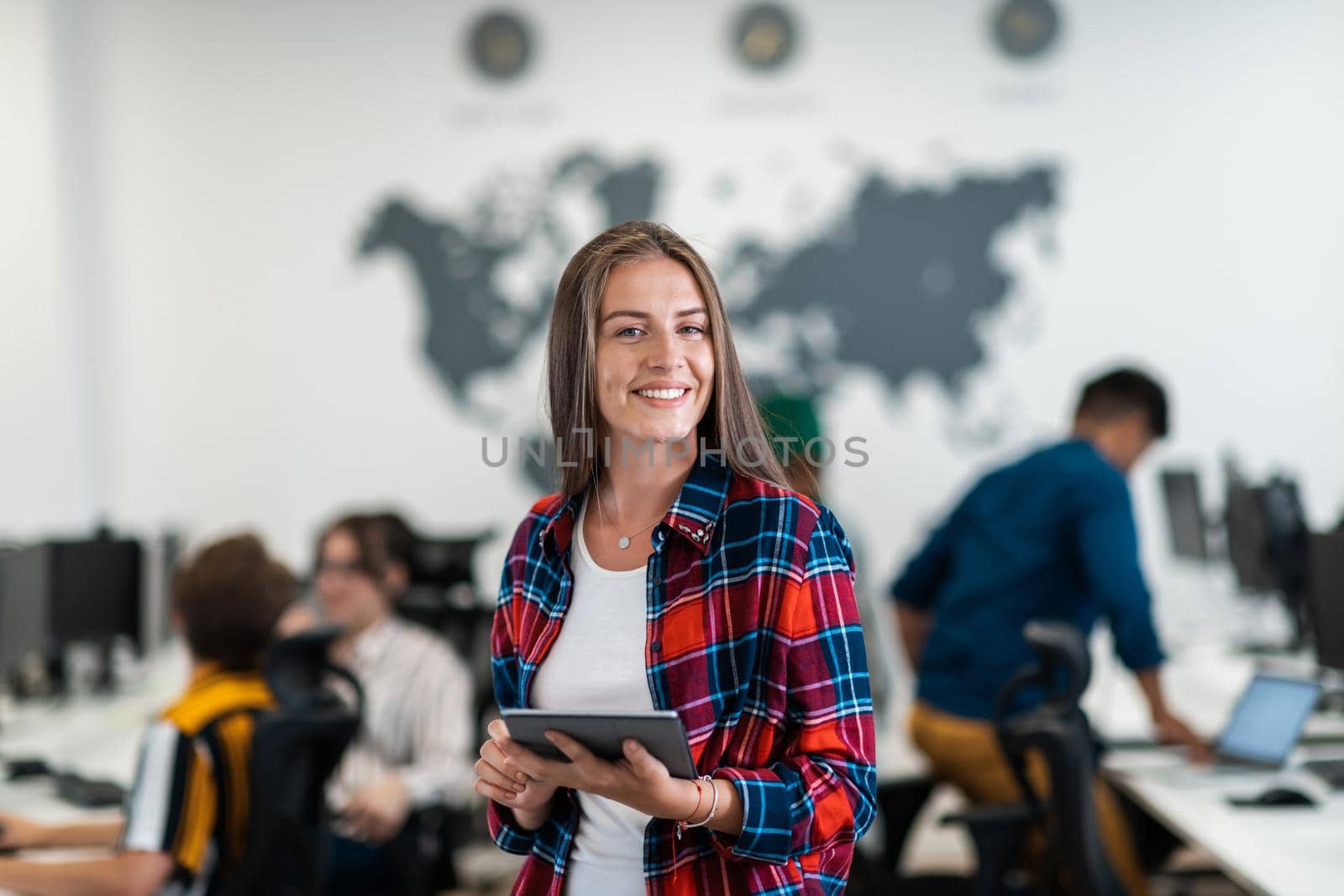 Portrait of businesswoman in casual clothes holding tablet computer at modern startup open plan office interior. Selective focus. High-quality photo