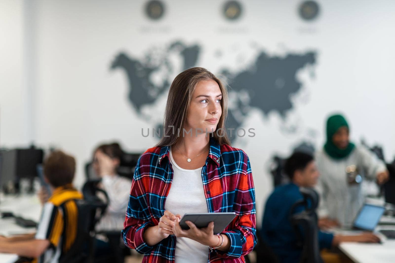 Portrait of businesswoman in casual clothes holding tablet computer at modern startup open plan office interior. Selective focus by dotshock