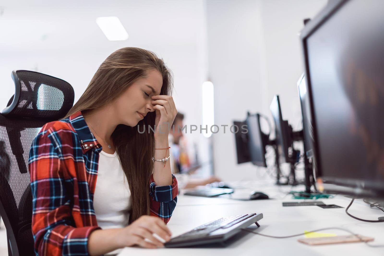 Beautiful Shocked and Annoyed Young Woman Looking her desktop. Sad Operator Agent Woman Working from Home in a Call Center by dotshock