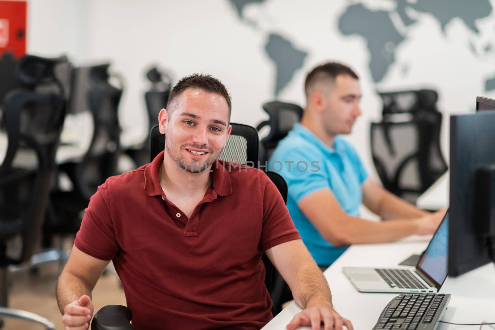 Group of Casual businessmen working on a desktop computer in modern open plan startup office interior. Selective focus. High-quality photo