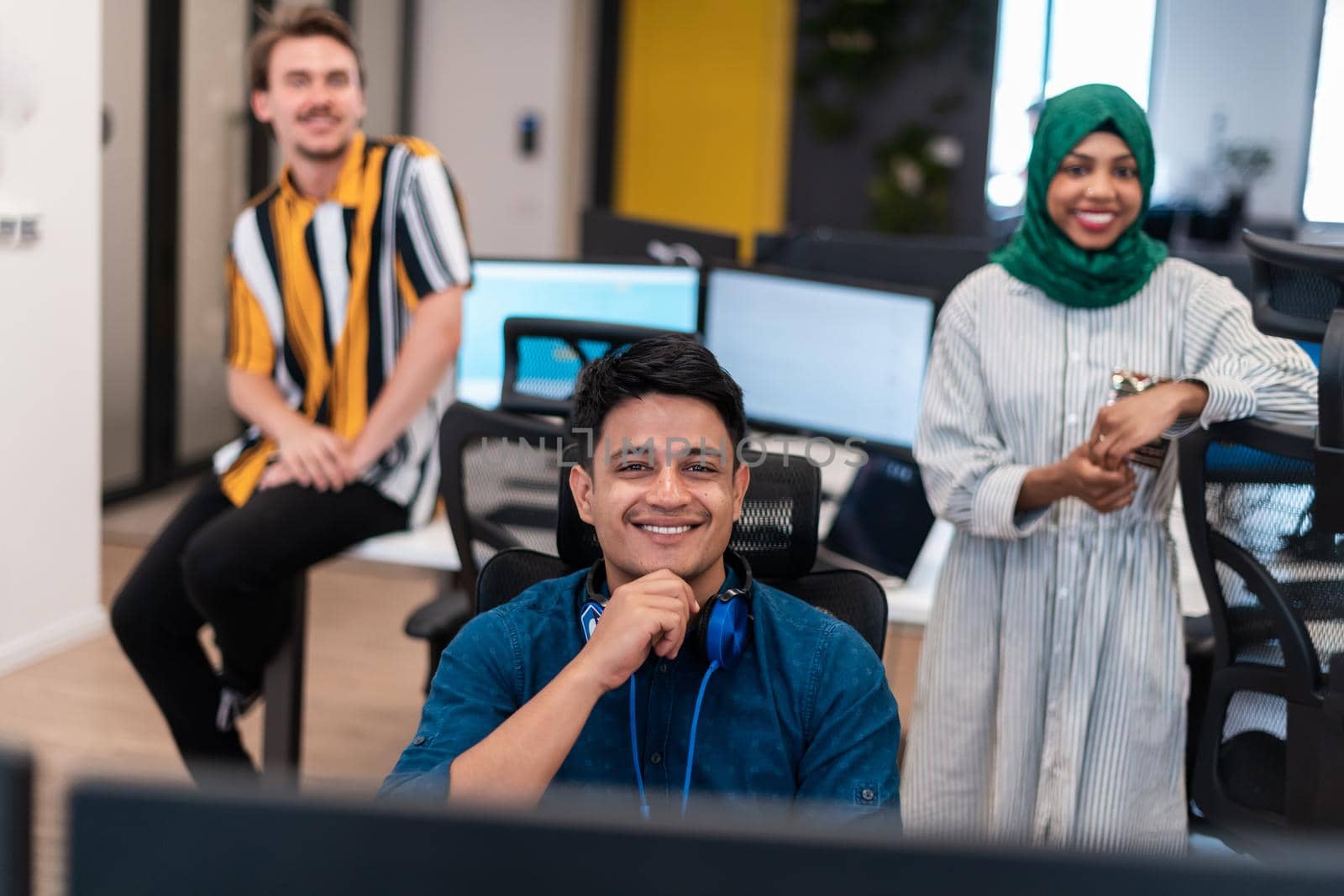 Multiethnic startup business team woman wearing a hijab on meeting in modern open plan office interior brainstorming, working on laptop and desktop computer. Selective focus. High-quality photo