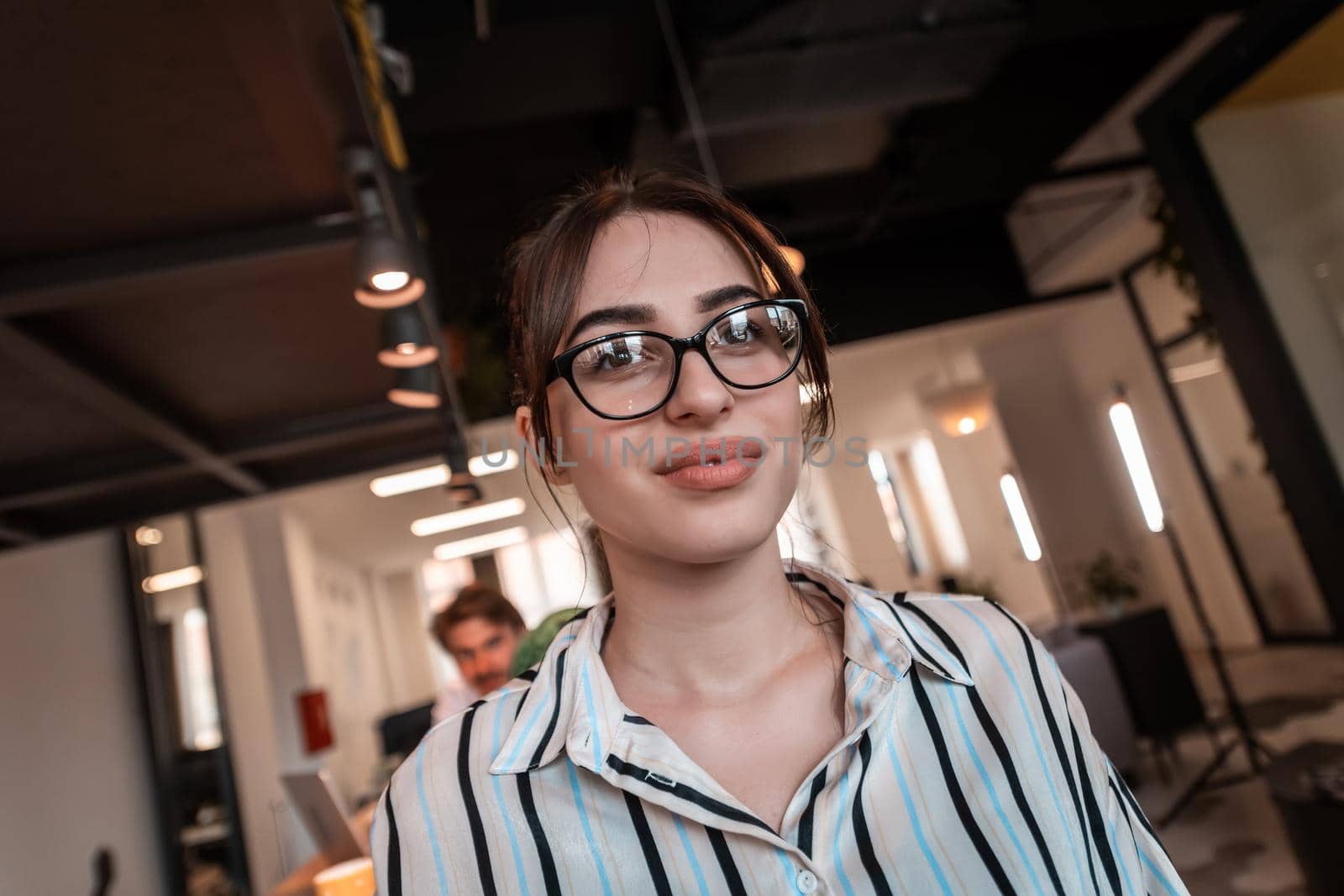Portrait of businesswoman in casual clothes with glasses at modern startup open plan office interior. Selective focus. High-quality photo