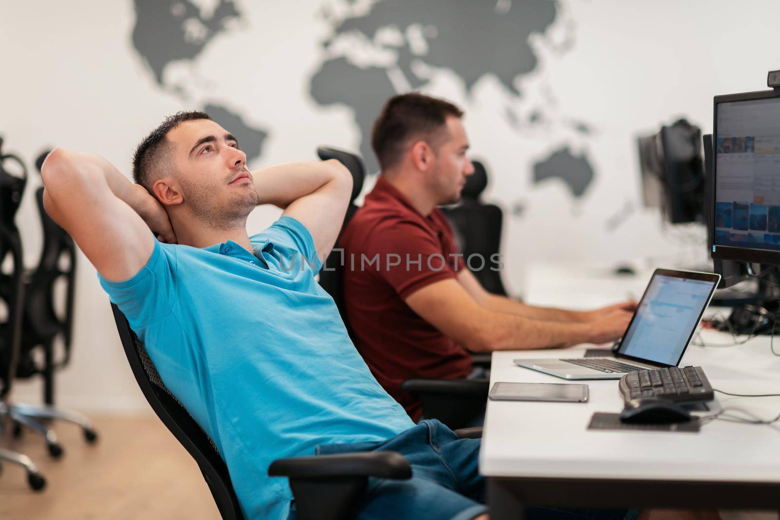 A time to relax. Young tired casual businessman relaxing at the desk in his office. Selective photo. High-quality photo