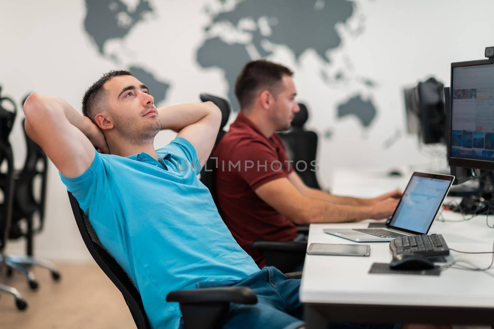 A time for relax. Young tired casual businessman relaxing at the desk in his office. Selective photo by dotshock