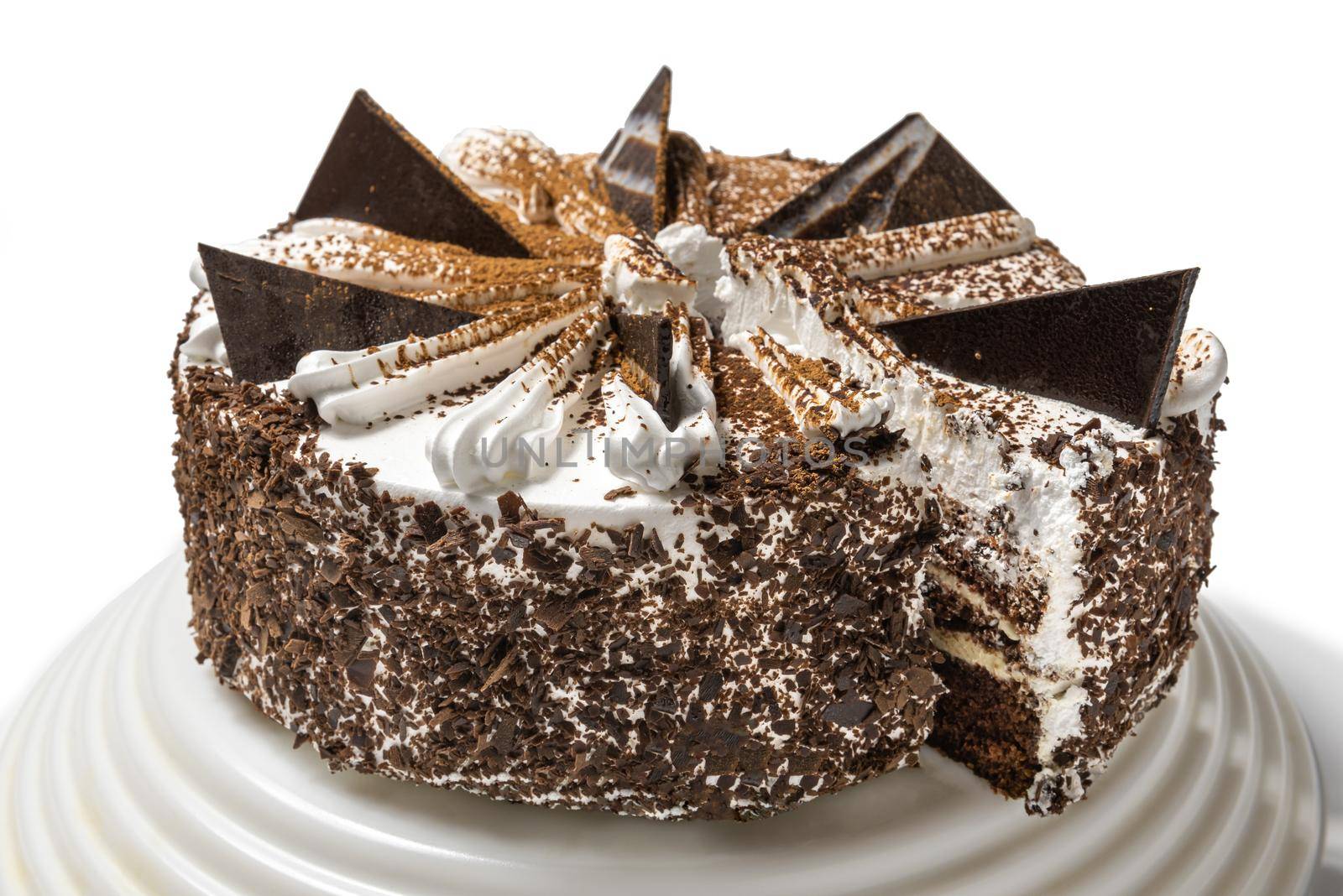 cake with chocolate, sprinkled with chocolate chips, on a tray on a white background with a cut piece by karpovkottt