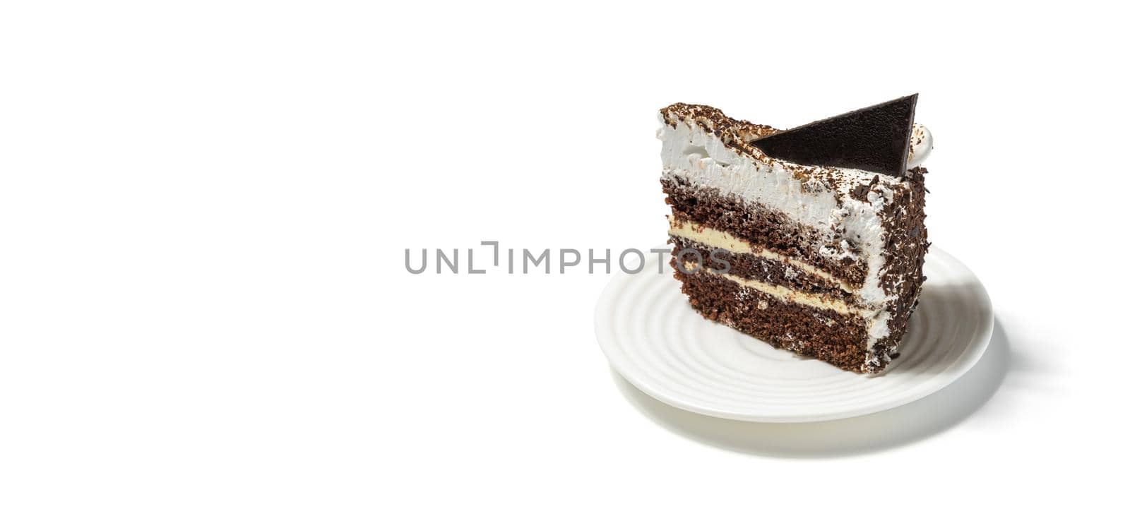Tasty chocolate cake on a white plate over white background banner format.